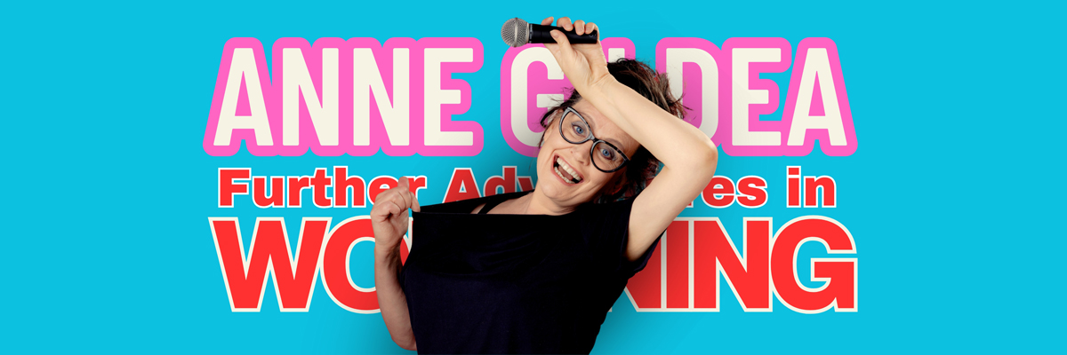 Comedian Anne Gildea standing in front of a bright blue background, with the words 'Anne Gildea' in pink and 'Further Adventures of Womaning' in red, wearing a black tshirt, holding a mic, pulling at her collar to indicate she's too warm.
